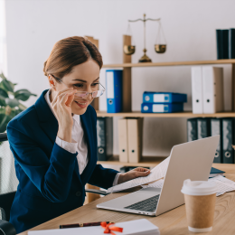 Photo of an individual sitting at a desk looking at a laptop.
